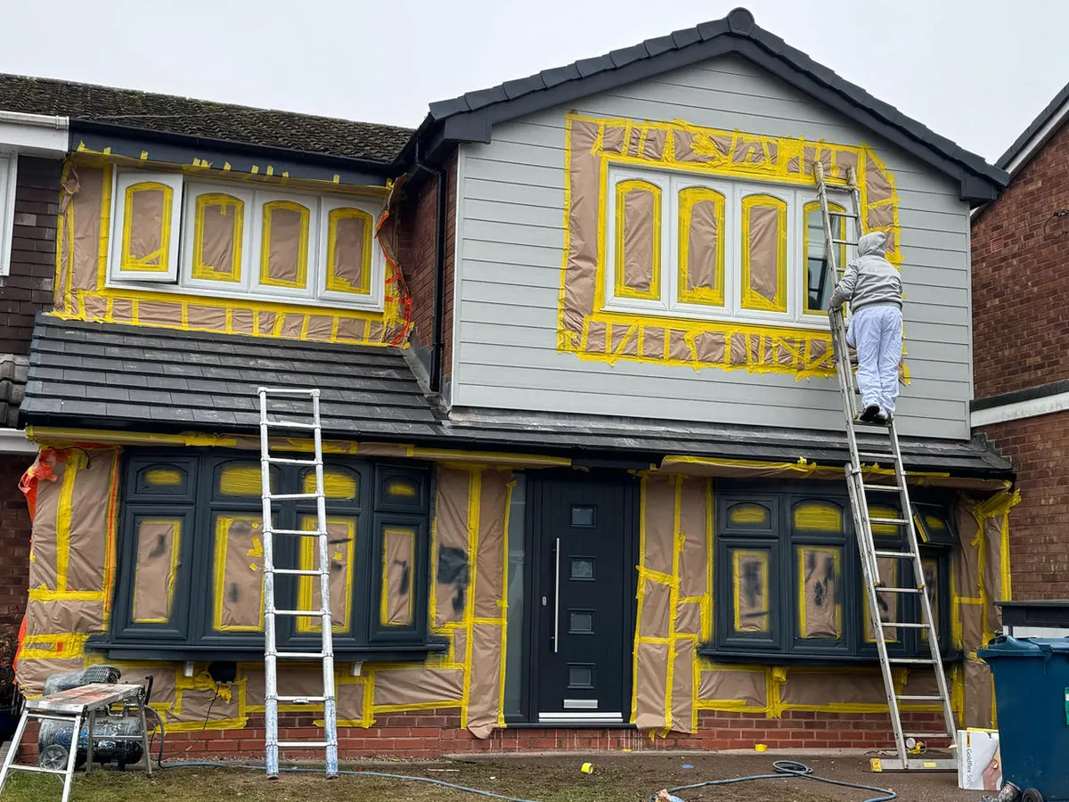 House exterior being prepared for UPVC spraying with all windows and frames carefully masked off