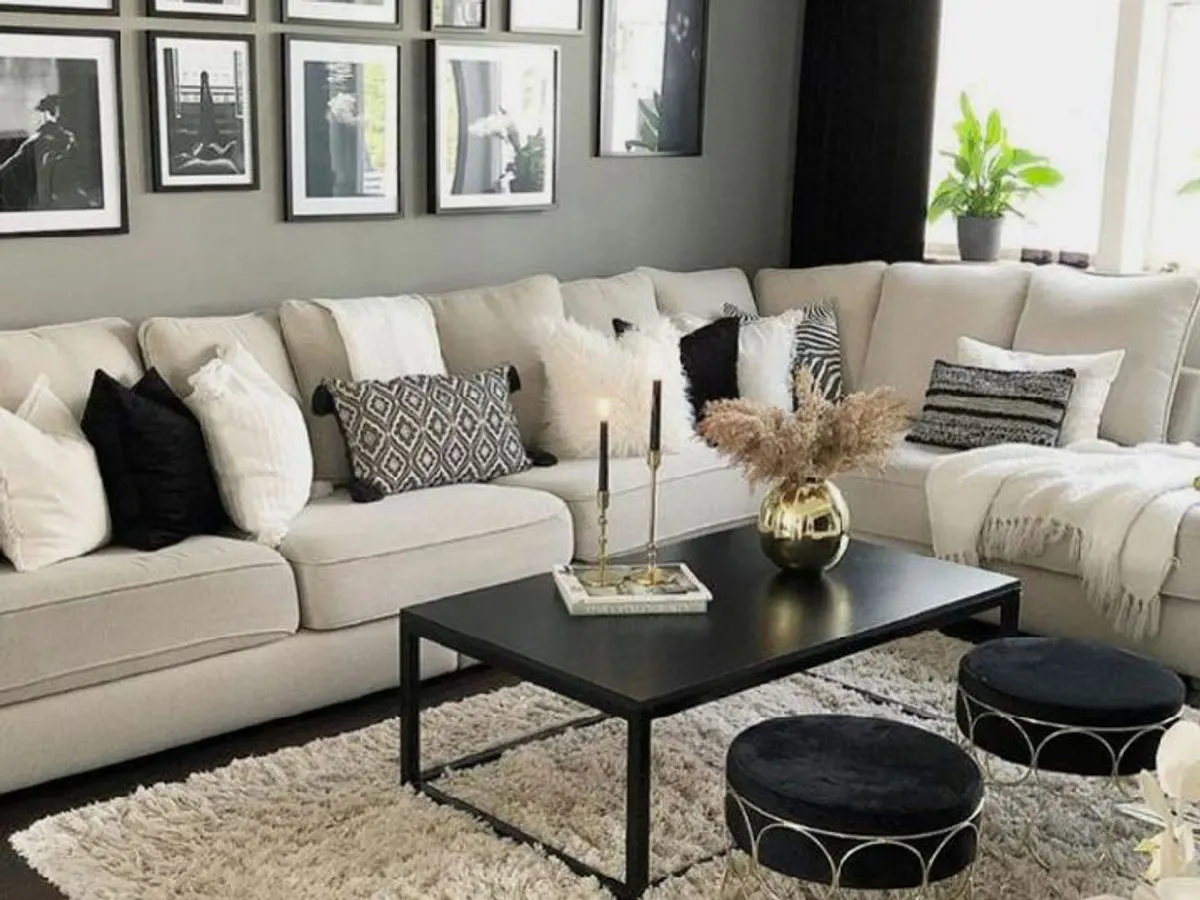 Stylish living room with dark grey feature wall cream corner sofa and gallery wall of framed prints