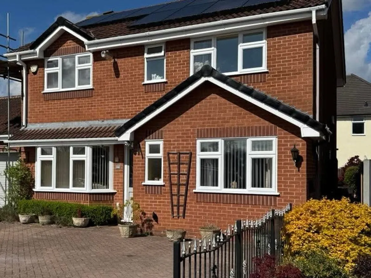Red brick detached house with freshly painted white UPVC windows fascias and soffits
